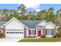 Charming single story home with a well maintained lawn, attached garage, brick accents, and a bright red front door at 799 Helms Way, Conway, SC 29526