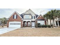 Charming two-story brick home with a well-manicured lawn, attached garage, and beautiful front yard landscaping at 8304 Parasol Ct., Myrtle Beach, SC 29579