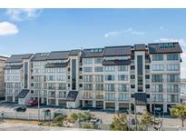 A multi-story condo building with a metal roof and private balconies offers covered parking below at 1398 Basin Dr. # 111, Murrells Inlet, SC 29576