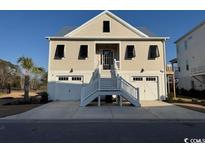 Charming coastal home with a metal roof, double garages, and inviting stairway to the main level at 172 Enclave Pl., Pawleys Island, SC 29585