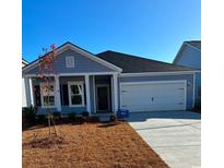 Charming single-story home with blue siding, an attached two-car garage and manicured front lawn at 2006 Lone Cypress Dr, Myrtle Beach, SC 29579