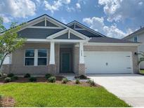 Charming single Gathering home with brick facade, well-manicured lawn, and inviting front porch at 2027 Copper Creek Loop, Longs, SC 29568