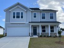 Charming two-story home featuring light gray siding, stone accents, a two-car garage, and a well-manicured lawn at 203 Wagner Cir., Conway, SC 29526