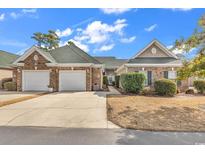 Charming brick home with a well-manicured lawn, a two-car garage, and a cozy, inviting entrance at 230 Nuthatch Ln. # C, Murrells Inlet, SC 29576