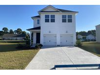 Charming two-story home featuring a two-car garage and a well-manicured front lawn at 413 Falling Leaf Loop, Myrtle Beach, SC 29588