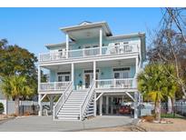 Charming raised beach home featuring multiple decks, inviting stairway, and light blue exterior at 516 S 8Th Ave.S, Surfside Beach, SC 29575