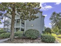 Charming condo exterior with wooden staircases, lush landscaping and mature trees, creating a serene outdoor setting at 5905 S South Kings Hwy. # 4309, Myrtle Beach, SC 29579