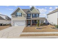 Charming two-story home featuring a well-manicured lawn, stone accents, and an attached two-car garage at 611 Cattle Drive Circle, Myrtle Beach, SC 29588