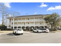 Three story condominium complex with white railings and parking spaces in front on a sunny day at 679 Riverwalk Dr. # 302, Myrtle Beach, SC 29579