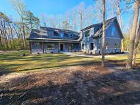 Craftsman-style home with covered porch and stone accents is nestled among tall trees at 8012 Old Reaves Ferry Rd., Conway, SC 29526