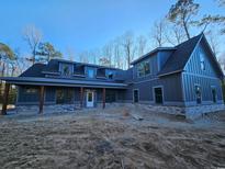 Beautiful two-story home with gray siding, stone accents, and a welcoming covered front porch at 8012 Old Reaves Ferry Rd., Conway, SC 29526