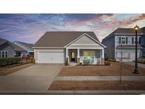 Charming single-Gathering home featuring a cozy front porch, well-manicured lawn, and an attached garage at 834 Summer Starling Pl., Myrtle Beach, SC 29577