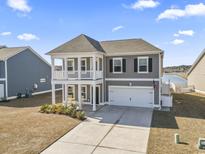 Charming two-story home boasts a double front porch and an attached two-car garage with a wide driveway at 1047 Harbison Circle, Myrtle Beach, SC 29579