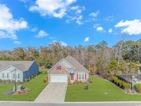 Charming single-Gathering home with stone accents, manicured lawn, and a two-car garage at 124 Castaway Key Dr., Pawleys Island, SC 29585