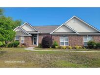 Charming brick home with lush landscaping and a well-manicured lawn at 153 Highmeadow Ln., Aynor, SC 29511