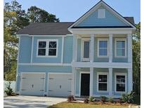 Charming two-story home featuring a two-car garage, black door, and lovely blue siding with white trim at 1800 Seachase Way, North Myrtle Beach, SC 29582