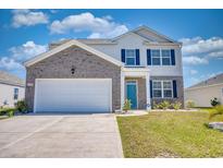 Charming two-story home with a two-car garage, blue shutters, well-manicured lawn, and welcoming curb appeal at 2106 Ainsley Dr., Little River, SC 29566