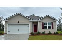 Charming single-story home featuring neutral siding, a red front door, and an attached garage in a cozy neighborhood at 214 Bald Cypress Way, Conway, SC 29527