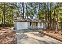 Charming single-story home with grey siding, an attached garage, and a well-maintained front yard at 2148 Brunswick Circle, Little River, SC 29566
