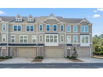 Attractive townhomes with a stone facade and covered entryways, each featuring an attached garage and landscaped front at 2557 Pete Dye Dr. # 403, North Myrtle Beach, SC 29582