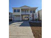 Charming elevated beach house with a spacious driveway, lush landscaping, and a two-story porch at 328 46Th Ave. N, North Myrtle Beach, SC 29582