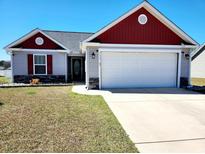 Charming single-story home featuring a two-car garage, landscaped yard, and beautiful red and gray accents at 3461 Holly Loop, Conway, SC 29527