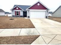 Charming single Gathering home featuring a two-car garage, red shutters and red trim at 3461 Holly Loop, Conway, SC 29527