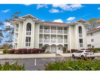 Charming condo building with multiple balconies, well-maintained landscaping, and convenient parking at 4648 Greenbriar Dr. # D7, Little River, SC 29566