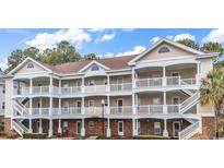 Attractive three-story condo building boasts multiple balconies with white railings and neutral color scheme at 5750 Oyster Catcher Dr. # 533, North Myrtle Beach, SC 29582