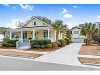 Charming yellow two-story home with a welcoming porch and manicured landscaping at 6514 Anchors Bend Dr Sw, Ocean Isle Beach, NC 28469