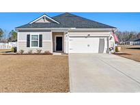 Charming single-story home featuring a well-maintained lawn, two car garage, and traditional design at 715 Lowell Avenue Dr., Little River, SC 29566