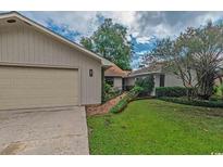 Charming single-story home featuring an attached garage and a well-maintained lawn at 906 Plantation Dr., Surfside Beach, SC 29575