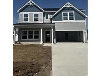 Charming two-story home featuring a two-car garage, gray siding, and classic architectural detailing at 911 Agostino Dr., Myrtle Beach, SC 29579