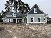 Beautiful craftsman style home with gray siding, dark trim, and a welcoming covered porch at 1007 Brood Ct., Conway, SC 29526