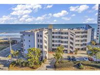 Beautiful oceanfront condo building with lush landscaping and ample parking spaces at 1310 N Waccamaw Dr. # 208, Garden City Beach, SC 29576