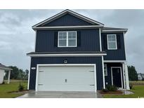 Two-story home with navy blue siding, a white garage door, and black shutters at 144 Leyland Cypress Dr, Conway, SC 29527