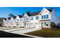 Charming townhomes with white siding, blue shutters, and well-manicured lawns offer an inviting curb appeal at 2374 Elowen Ln. # 24A, Longs, SC 29568