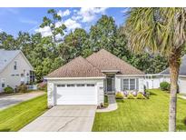 Charming one-story home featuring a well-manicured lawn and an attached two-car garage at 322 Crooked Oak Dr., Pawleys Island, SC 29585