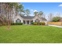 Charming one-story home featuring a manicured lawn, complemented by mature trees and decorative landscaping at 3471 Spivey St., Loris, SC 29569