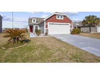 Charming home with a two-car garage, red door, manicured lawn and lovely curb appeal at 351 Stafford Dr., Myrtle Beach, SC 29579