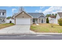 Charming single-story home with a well-manicured lawn and a two-car garage, with neutral beige siding and a gabled roof at 378 Thistle Ln., Myrtle Beach, SC 29579