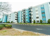 Multi-story building featuring balconies with nice landscaping and visible parking in front at 5001 Little River Rd. # E-407, Myrtle Beach, SC 29577