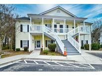 Inviting two-story condo with charming yellow siding, white railings, and well-maintained landscaping at 5046 Belleglen Court # 101, Myrtle Beach, SC 29579