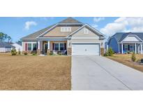 Charming single-Gathering home featuring a two-car garage, stone accents, and manicured lawn at 925 Oak Hollow St., Longs, SC 29568