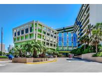 View of the Coral Beach Resort entrance with palm trees and a well-maintained, colorful facade against a bright blue sky at 1105 S Ocean Blvd. # 732, Myrtle Beach, SC 29577