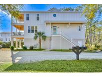 Charming coastal home with a white exterior, multiple balconies, and a well-manicured yard, creating an inviting curb appeal at 114 Half Shell Ct., Pawleys Island, SC 29585
