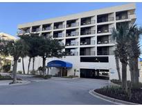 Exterior view of the Sand Dunes Villas building, with a covered entrance and parking garage at 201 N 74Th Ave. N # 2322, Myrtle Beach, SC 29572