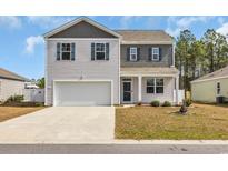 Charming two-story home featuring a two-car garage and a well-maintained lawn on a sunny day at 220 Forestbrook Cove Circle, Myrtle Beach, SC 29588