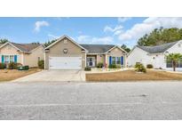 Charming single-story home featuring a well-manicured lawn, tidy landscaping, and an attached two-car garage at 224 Cupola Dr., Longs, SC 29568