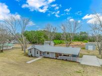Well-maintained home featuring grey brick and metal roof, nestled on a spacious lot with mature trees at 2360 Highway 701 North, Loris, SC 29569
